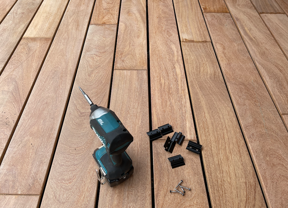 Drilling into durable Ipe hardwood decking boards with a cordless drill during installation