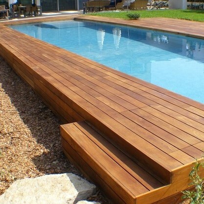 Luxurious outdoor Ipe decking installed around a sunken swimming pool in a modern garden
