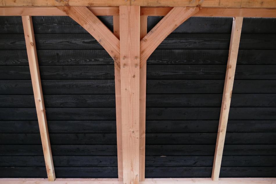 Black Douglas fir feather edge cladding installed on a garden canopy wall
