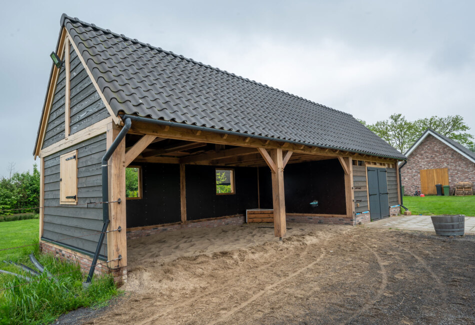 Bespoke Douglas fir and oak garden shelter featuring traditional joints and black cladding