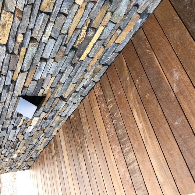 Smooth Ipe outdoor parket boards installed seamlessly along an outdoor garden wall