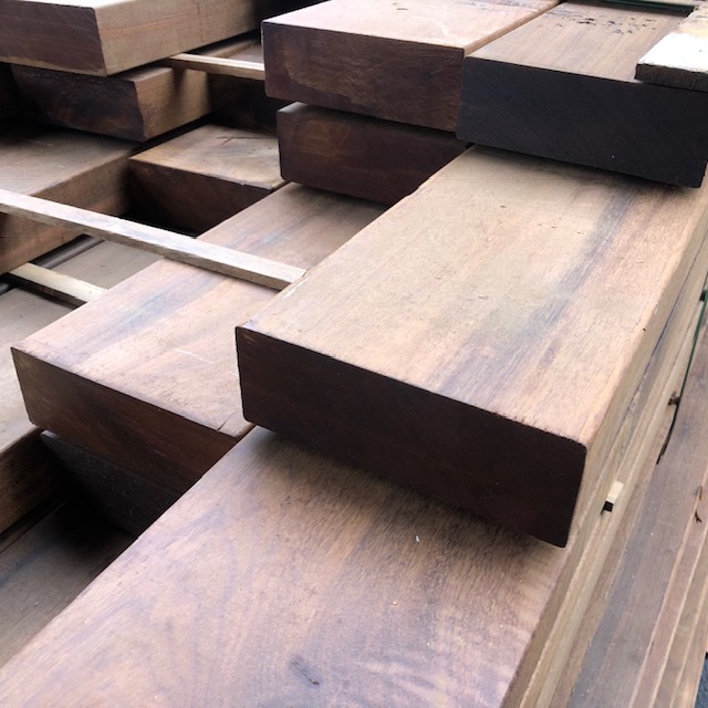 Smooth planed Ipe timber beams neatly stacked with wooden battens
