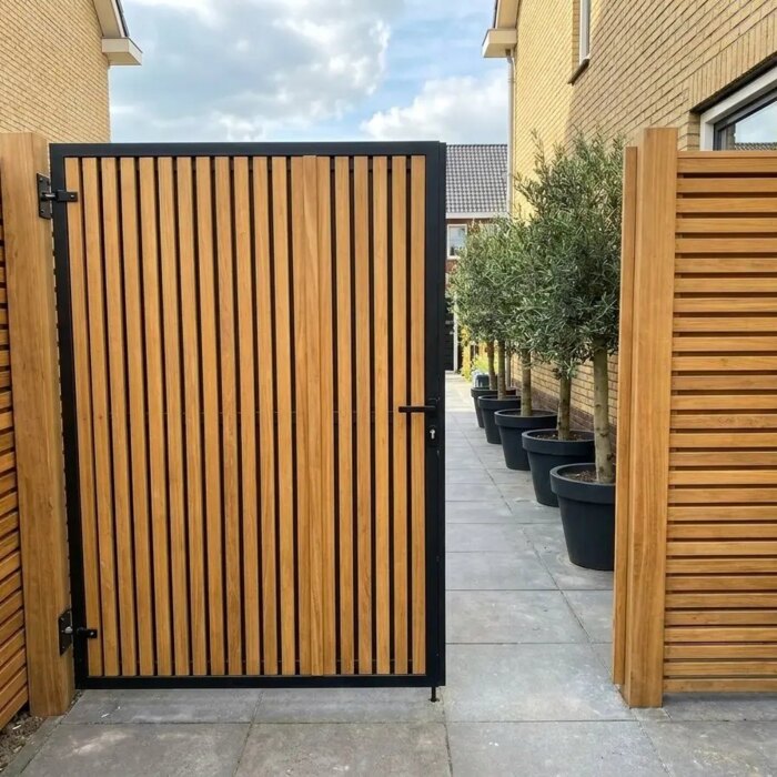 Bespoke teak garden gate with 70 mm slats in a narrow side passage Bespoke teak garden gate with 70 mm slats in a narrow side passage