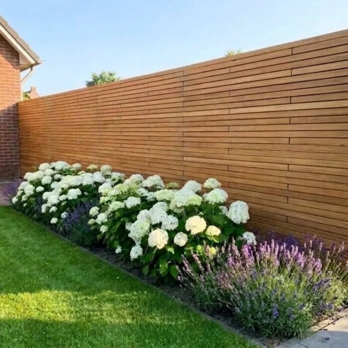 Real teak fence with 50 mm slats behind a border of white hydrangeas