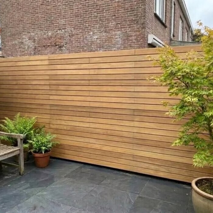 Teak privacy fence with 90 mm slats in a town garden with a Japanese maple Teak privacy fence with 90 mm slats in a town garden with a Japanese maple