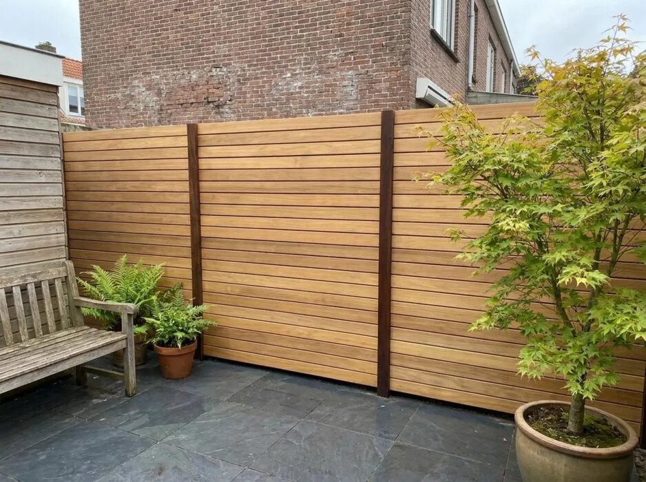 Teak fence with 9 cm slats in a courtyard garden with a Japanese maple