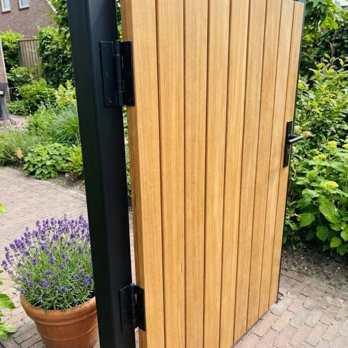 Close-up of the black hinge on the teak gate with 70 mm slats