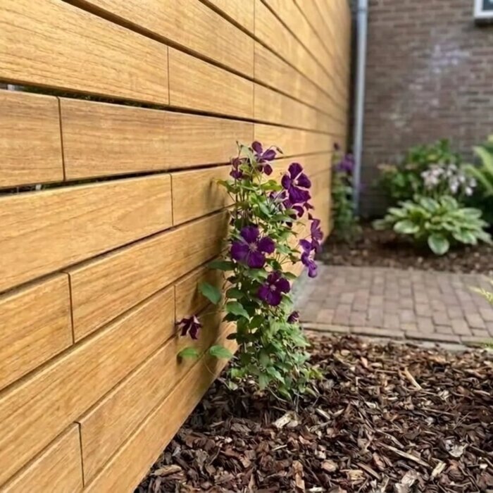 Teak slats of 70 mm with the clips hidden in the gap, next to an Azobé post Teak slats of 70 mm with the clips hidden in the gap, next to an Azobé post
