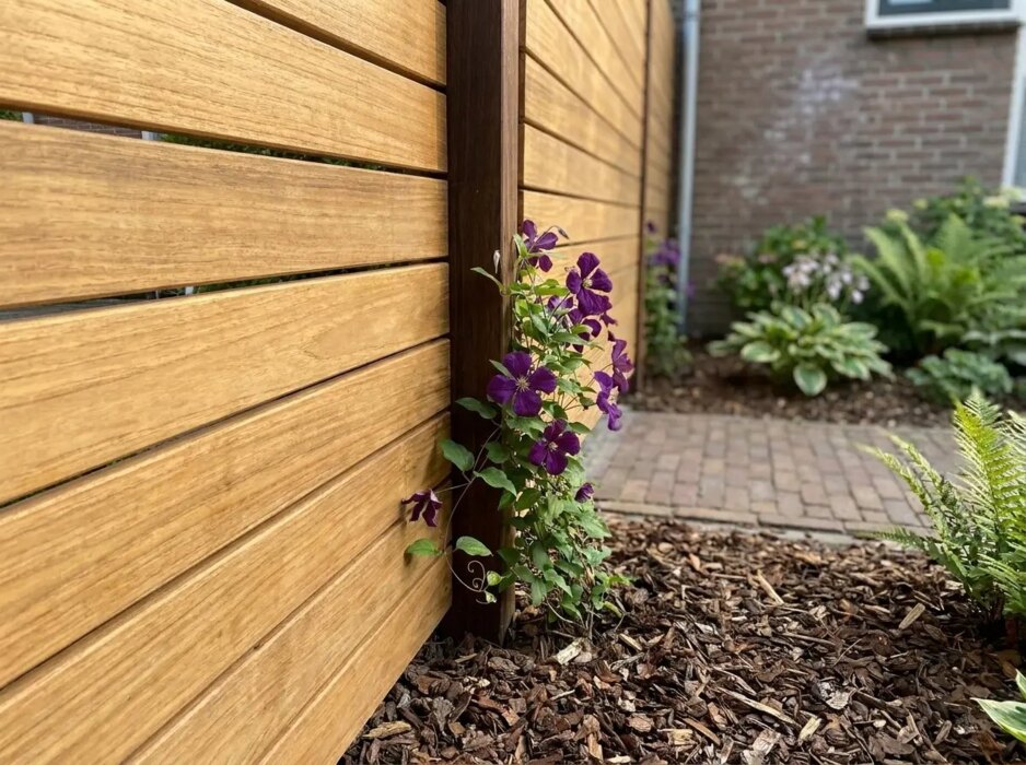 Close-up of 7 cm teak slats at an azobe post with clematis