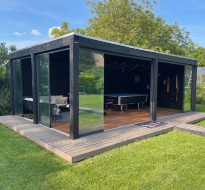 Modern garden house with glass doors and decking