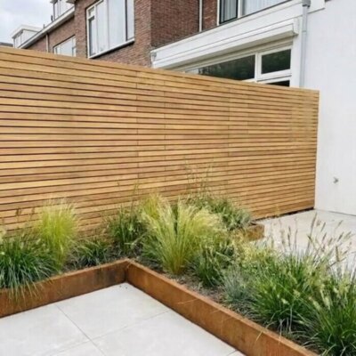 Teak fence with 5 cm slats in a back garden with a corten steel raised bed