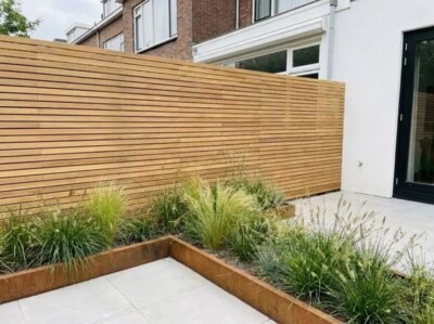 Teak fence with 5 cm slats in a back garden with a corten steel raised bed