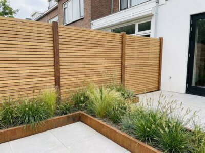 Teak fence with 5 cm slats in a back garden with a corten steel raised bed