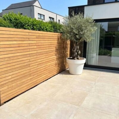 Teak fence with 7 cm slats in a new build garden with an olive tree
