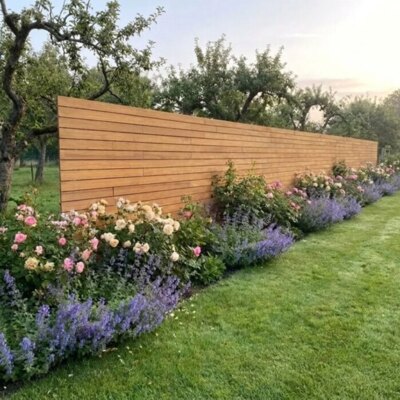 Teak fence with 9 cm slats in a country garden with roses and fruit trees