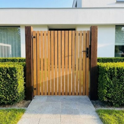 Teak garden gate with 70 mm slats in the front garden of a modern white house