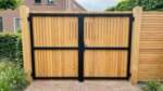 Teak bespoke double gates clad on one side, back view with black frame