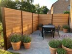 Teak fence with 7 cm slats around a patio corner with a dining table