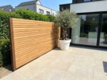Teak fence with 7 cm slats in a new build garden with an olive tree