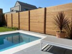 Teak fence with 9 cm slats beside a swimming pool in a modern garden