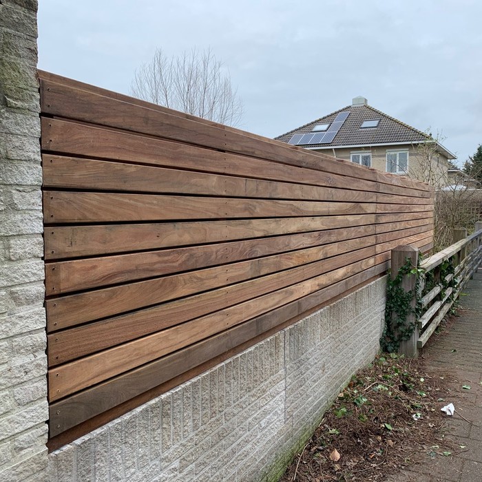 Low Ipé fence with 9cm slats on a wall using hidden clip fasteners