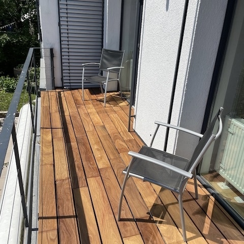 Modern balcony featuring durable Ipe hardwood decking boards for a premium natural look