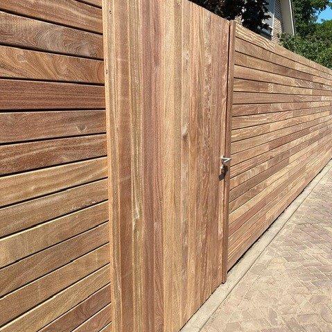 Premium Ipe slatted fencing using 9 cm wide slats with a seamless matching pedestrian gate for garden security and style