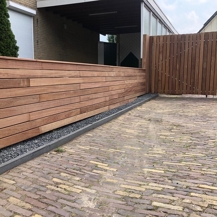 Low Ipe hardwood fence panels mounted on top of a garden wall