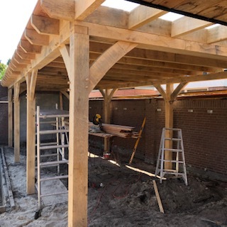 Robust oak timber frame structure for a luxury garden building with traditional joinery